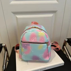 Mini pastel gradient backpack with heart patterns and gold zipper on a white stand