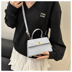 Détail du sac bandoulière bleu clair avec texture marbrée et fermoir rotatif doré
