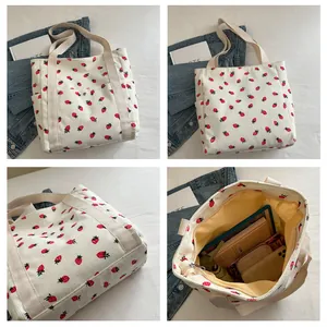 Detailed views of strawberry print tote bag showing corduroy texture and large interior