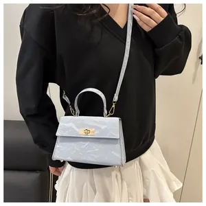 Détail du sac à bandoulière bleu clair avec texture plissée et fermoir rotatif doré