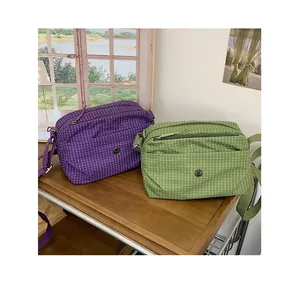 Vue détaillée des sacs à bandoulière à carreaux violets et verts avec fermeture