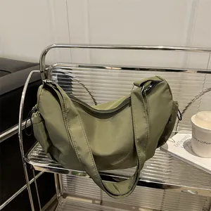 Minimalist green nylon hobo bag with wide shoulder strap and large capacity design