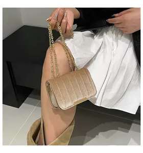 Detalle del bolso bandolera de terciopelo champán con acolchado y cadena dorada