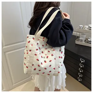 Close-up of strawberry print corduroy tote bag featuring soft texture and magnetic buckle