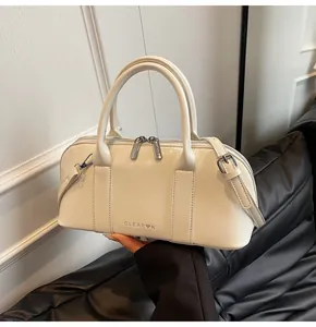 Detalle del bolso de cuero blanco crema con herrajes plateados y logo de marca visible