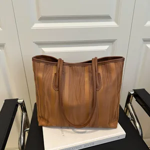 Chic tote bag with brown vertical wavy texture on a chair, 2025 summer fashion style