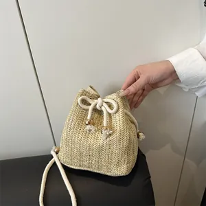 Secchiello minimalista in paglia intrecciata con coulisse e dettagli di perle dorate