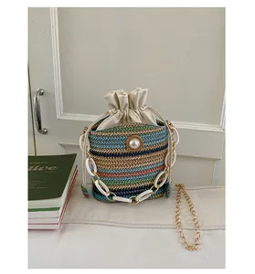 Close-up of colorful woven bucket bag with large pearl detail and drawstring top