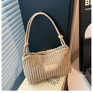 Detailed view of beige corduroy tote texture with zipper and decorative patch