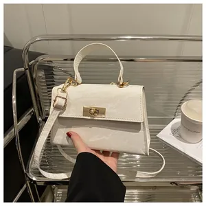 Vue détaillée du sac bandoulière blanc à texture marbre et fermoir rotatif doré