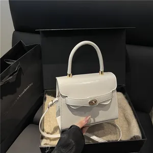 Elegante borsa a mano in pelle verniciata bianca con chiusura girevole dorata e tracolla
