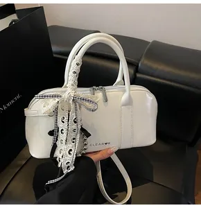 Detalle de bolso Boston blanco brillante con logo CLEAR❤K y lazos de encaje decorativos