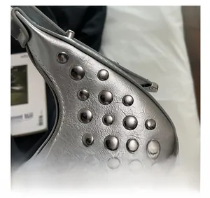 Macro detail of metallic silver leather bag with round polished metal rivets and texture
