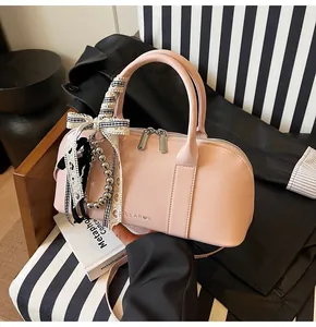 Bolso rosa estilo Boston con lazo de encaje a cuadros y detalle de colgante de metal