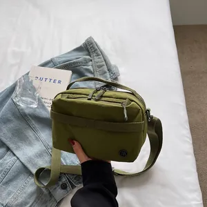 Olive green nylon crossbody bag with multiple zip pockets and adjustable strap for women