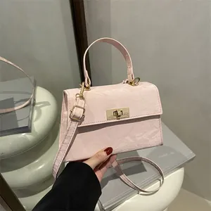Sac bandoulière rose plissé avec fermoir rotatif doré et bandoulière amovible