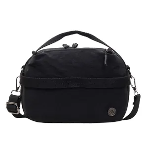 Minimalist black waterproof nylon crossbody bag with top handle and adjustable strap