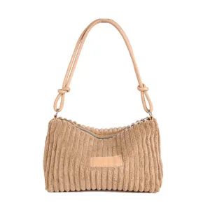 Brown corduroy tote bag with leather straps and knot details on a white background