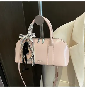Detalle del bolso Boston rosa de cuero sintético con lazo de cuadros y cadena plateada