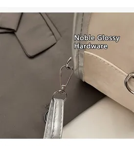 Nahaufnahme der silbernen Metallschnalle und des glänzenden Riemens am beigen Rucksack