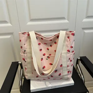 Pink corduroy tote bag featuring fresh strawberry prints and white woven handles