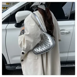 Close-up of silver crescent moon bag with metallic studs on synthetic leather strap