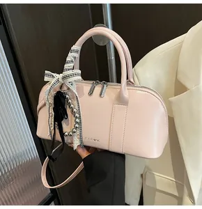 Bolso Boston rosa brillante con grabado de corazón y lazo decorativo sujeto a mano
