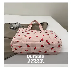 Detailed close-up of the wear-resistant bottom on this pink corduroy strawberry tote bag