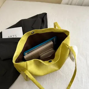 Detailansicht der gelben Ledertasche mit silberner Magnetschnalle und großem Innenraum