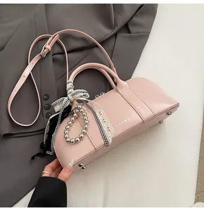 Detalle de bolso rosa con colgante de corazón de encaje y decoraciones de lazos