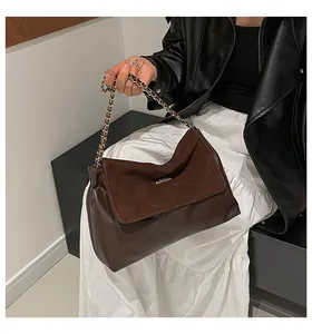 Detail view showing textured patchwork of brown smooth leather and soft suede chain bag