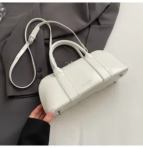 Detalle del bolso boston de cuero blanco con logo CLEAR K y pies metálicos de apoyo