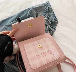 Detail showing high-quality magnetic snap closure and cute puppy bear pattern on pink bag