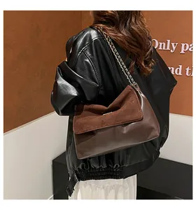 Detail of vintage brown tote featuring mixed matte and smooth leather with gold chain