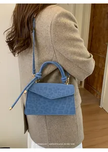 Détail du sac bandoulière bleu à motif léopard avec une poignée nouée sophistiquée