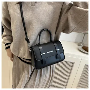 Détail d'un sac bandoulière avec texture cuir mixte et logo FASHION & BAGS