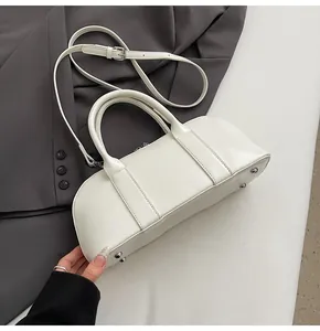 Detalle del bolso bowling blanco crema con remaches protectores plateados y cuero liso fino