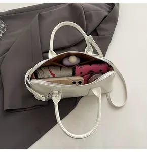 Vista interna de un espacioso bolso Boston blanco que muestra espacio para accesorios