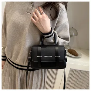 Gros plan du sac boîte en cuir noir avec détails argentés et texture grainée chic