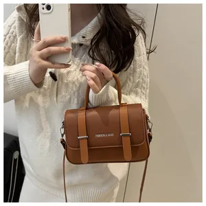 Détail du sac boîte en cuir marron avec boucles argentées et logo Fashion & Bags