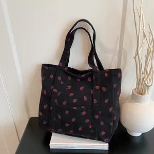 Large black corduroy tote bag with red strawberry print and wide shoulder straps