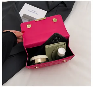 Interior view of fuchsia quilted crossbody bag showing storage for phone and makeup