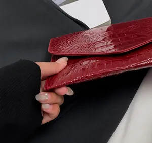 Detail shot of the precise stitching on the red crocodile pattern crossbody bag
