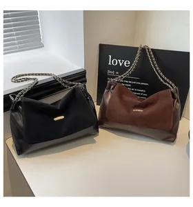 Detail of vintage tote bags in black and brown leather with elegant chain straps