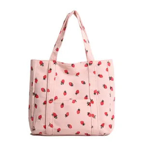 Pink corduroy tote bag with strawberry patterns and a convenient front pocket