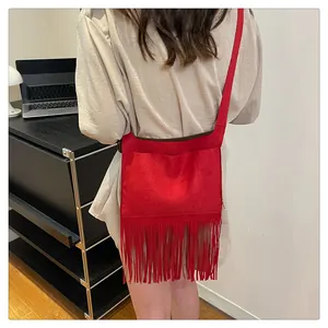 Vue détaillée d'un sac bandoulière en daim rouge avec de longues franges bohèmes