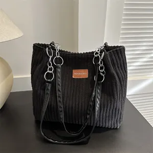 Large black corduroy tote bag with metal chain straps and leather patch for women