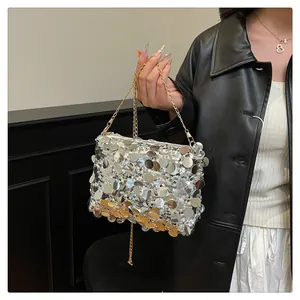 Dettaglio di paillettes argento scintillanti e catena dorata su una borsa da sera elegante