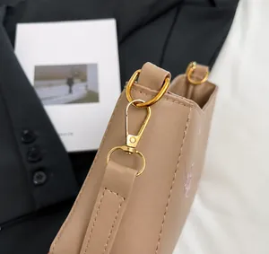 Nahaufnahme der goldenen Metallbeschläge und Karabinerhaken an der Lederhandtasche