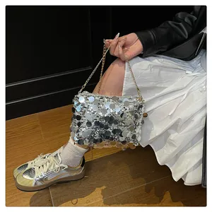 Dettaglio borsa a tracolla in paillettes argento con catena in metallo dorato